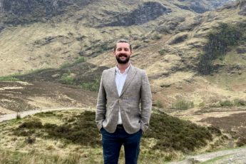 Travel Concierge John Jennings stands amongst the hills of Scotland