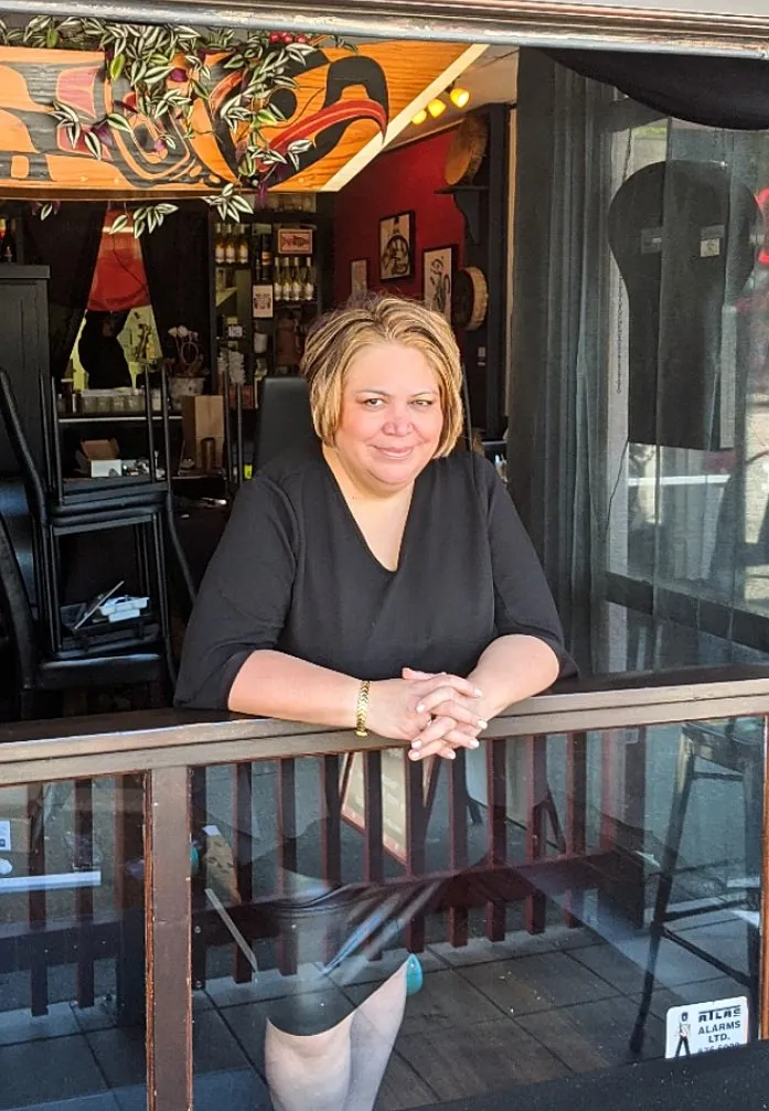 Salmon n' Bannock owner Inez Cook leaning on a railing inside the restaurant