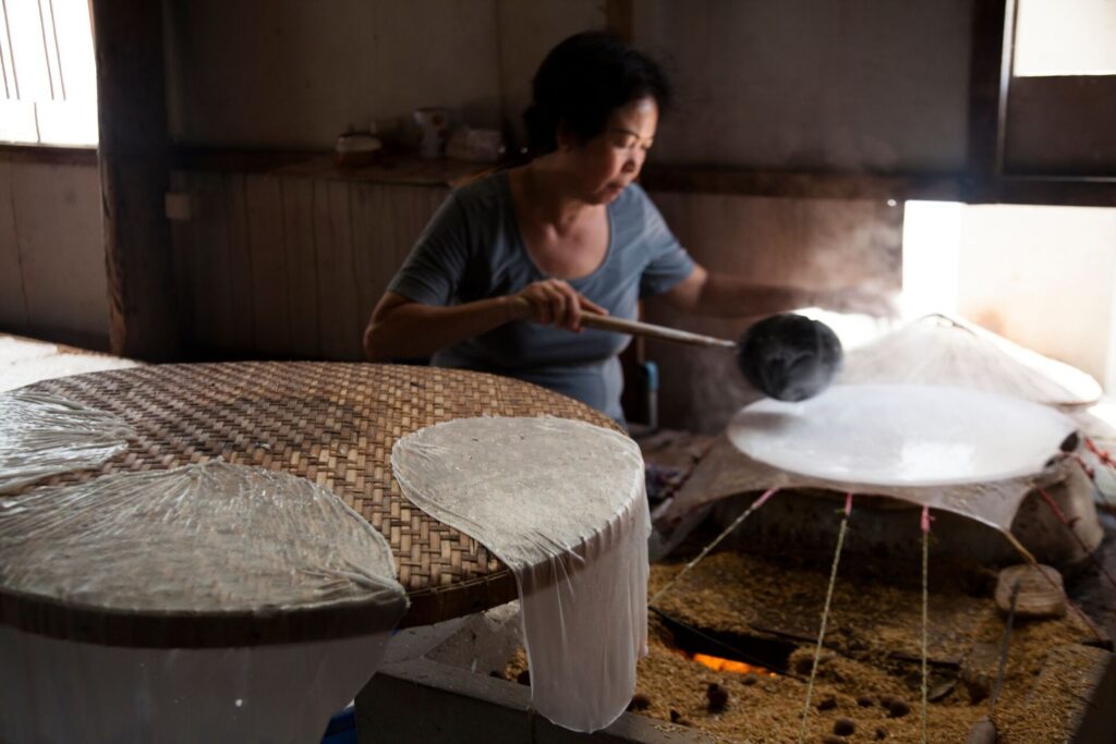 woman making rice paper in Cambodia