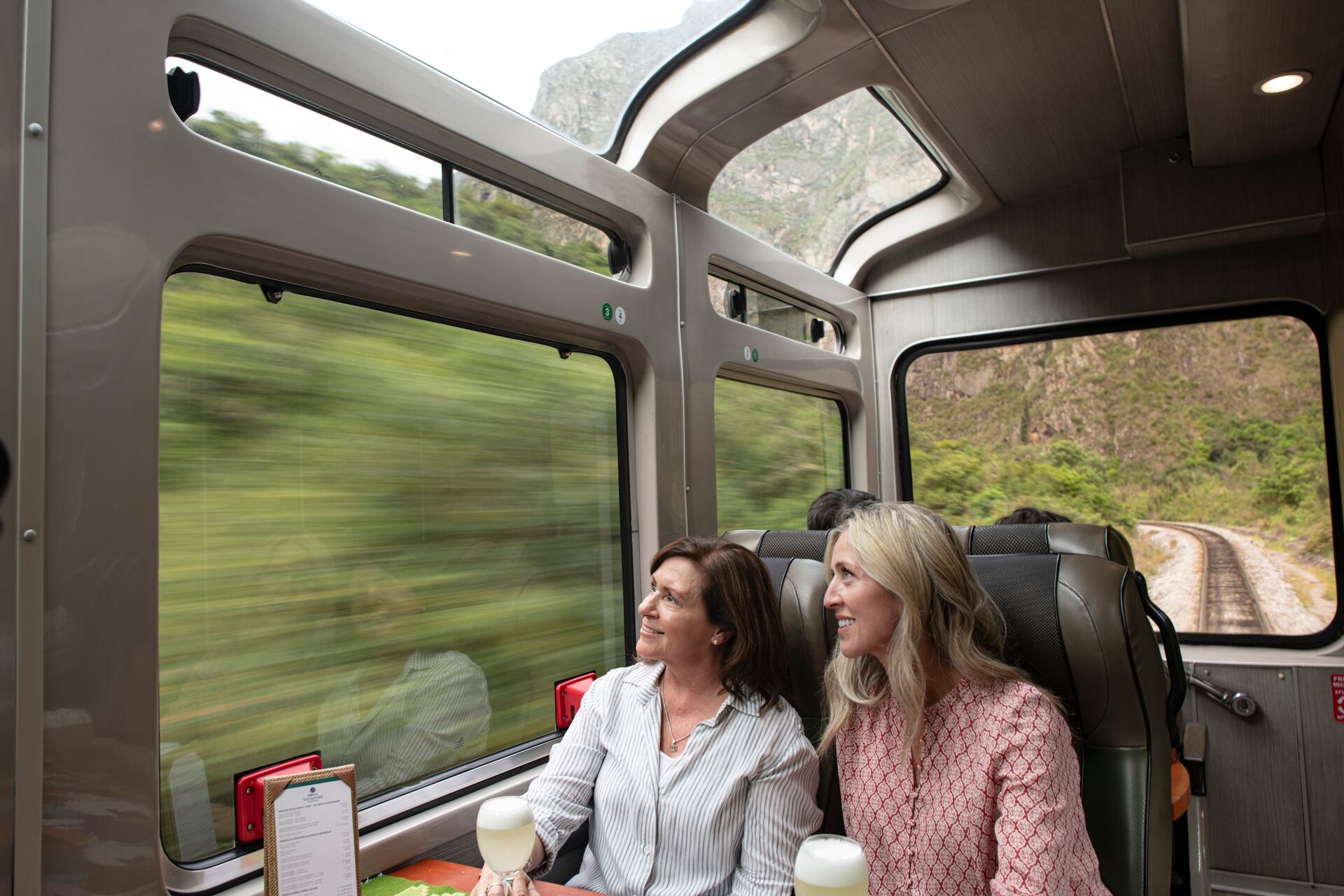 Two female passengers riding on the Vistadome train, Peru