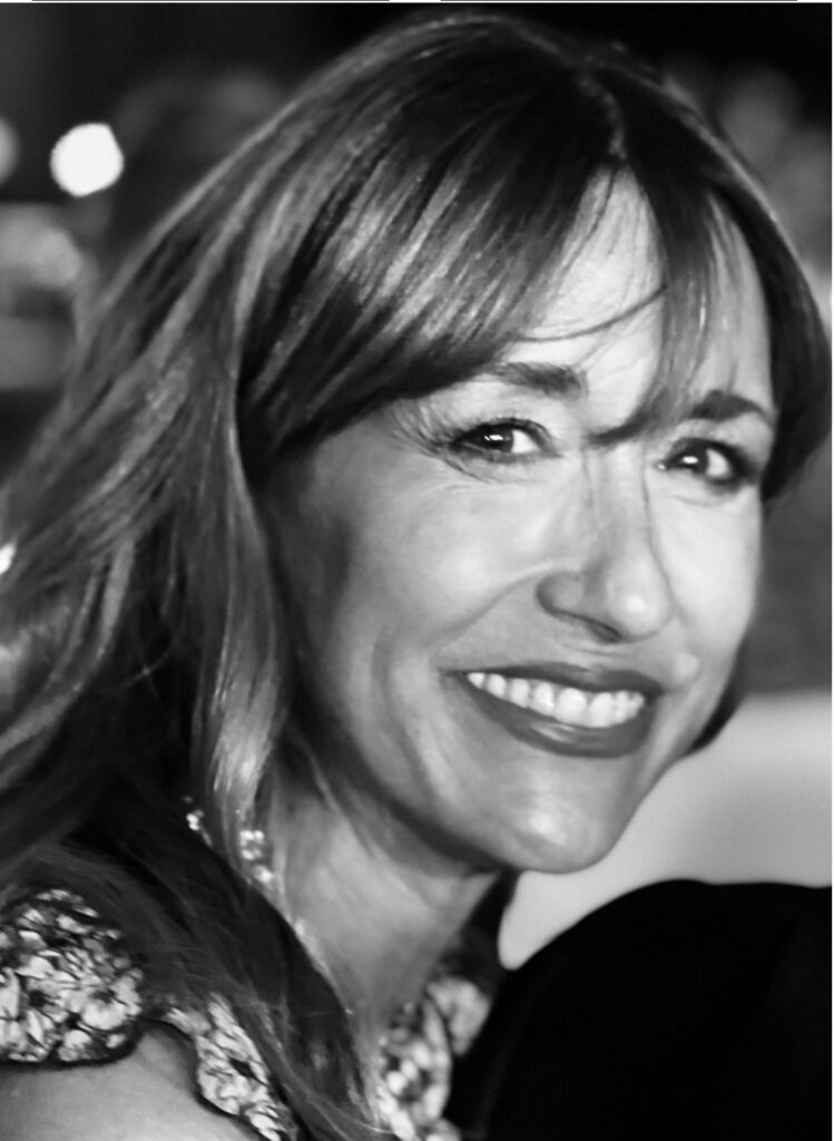 A black and white headshot of Alexandra Hoffer smiling at the camera