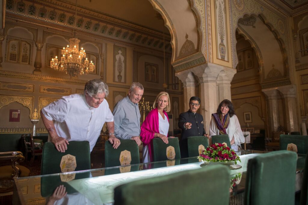 Four Luxury Gold guests are examining a table in an ornate private room of the Jaipur City Palace.