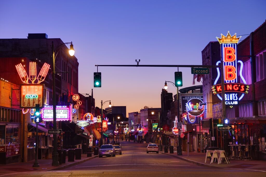 View looking down a neon sign-lined street at dusk in America 
