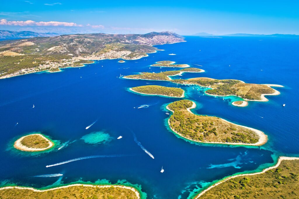 Green Islands of Croatia’s Dalmatian Coast dot the bright blue sea 