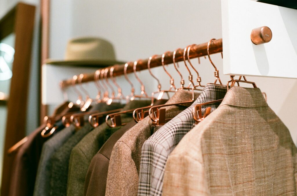 Rail of men's suits on copper hangers