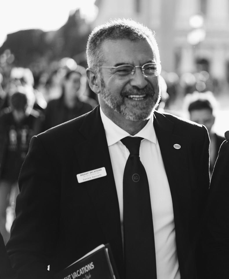 Luxury Gold Travel Concierge Daniele wars a black suit and a smile.