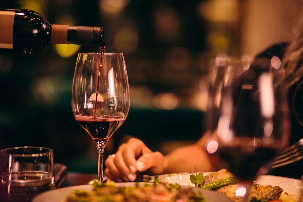Close up of red wine being poured a high end restaurant.