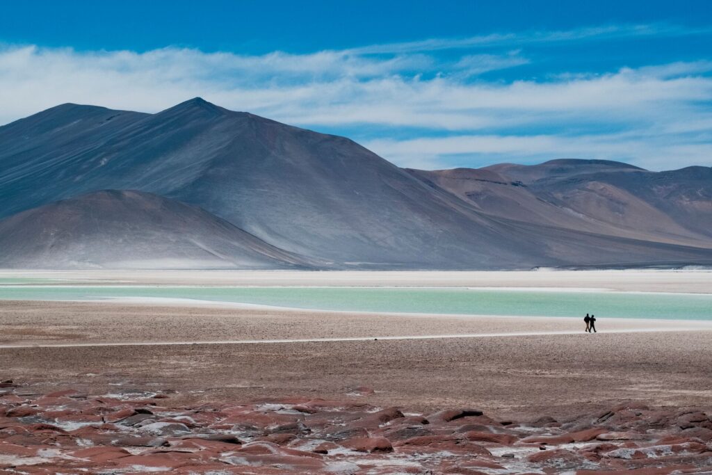 A green shallow lake and desert covered mountains in the Atacama desert, Chile