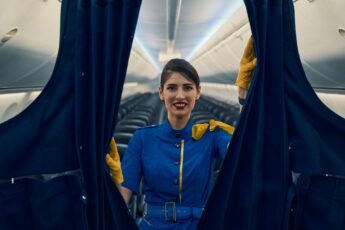 Air stewardess closes partition curtains to First Class section