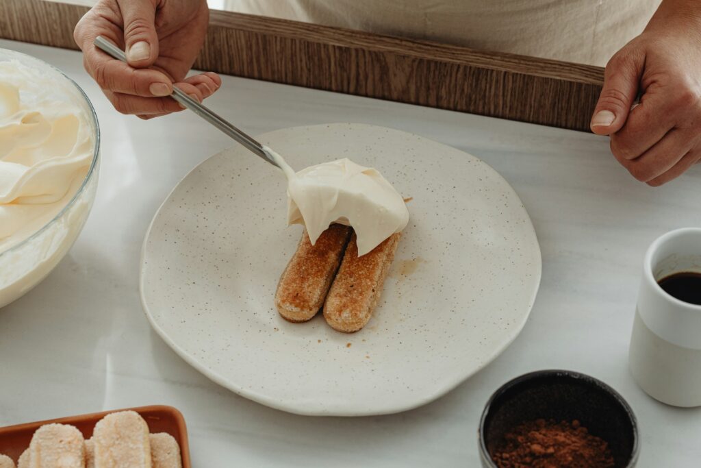 Chef spooning cream onto a dessert