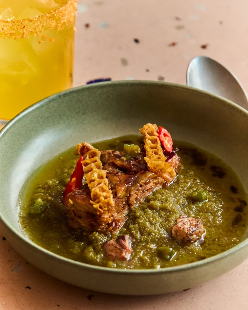 Bowl of African-inspired food with a yellow colored cocktail