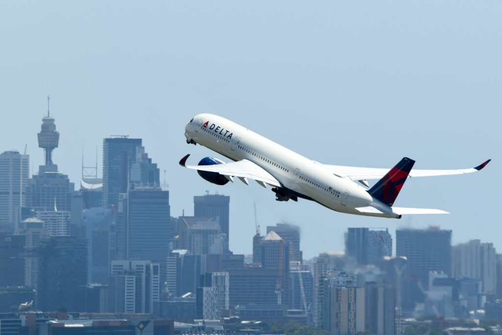 Delta plane taking off with city buildings in the background