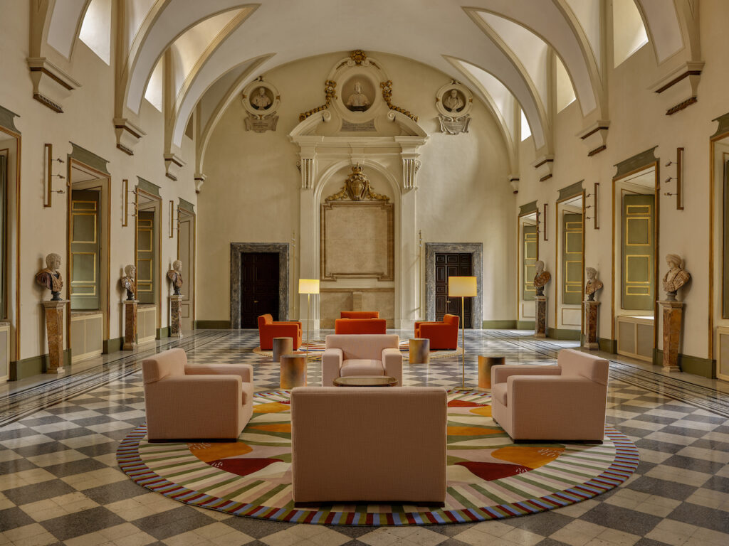 Interior of hotel lobby with marble floor, vaulted ceilings and colourful sofas
