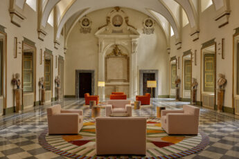 Interior of hotel lobby with marble floor, vaulted ceilings and colourful sofas
