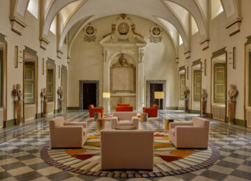 Interior of hotel lobby with marble floor, vaulted ceilings and colourful sofas