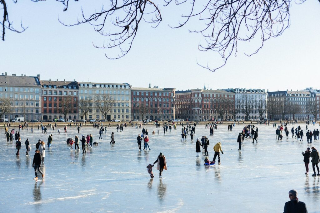 People ice skating on frozen harbour in Copenhagen in the winter