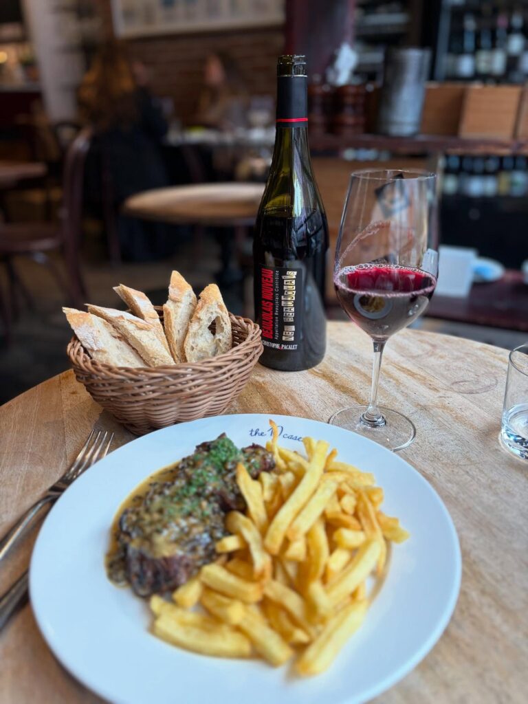 Steak frites with a glass and bottle of red wine at a restaurant