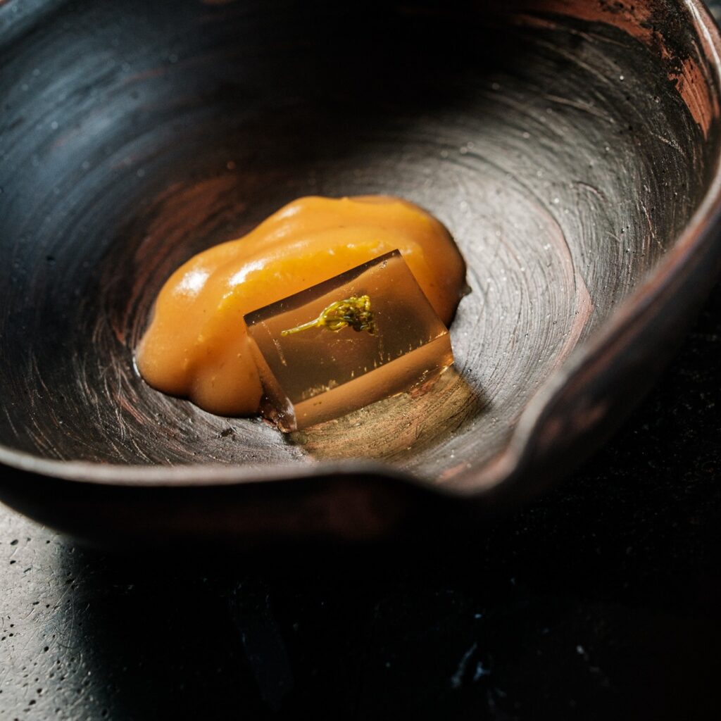 Artful orange dessert in a black bowl