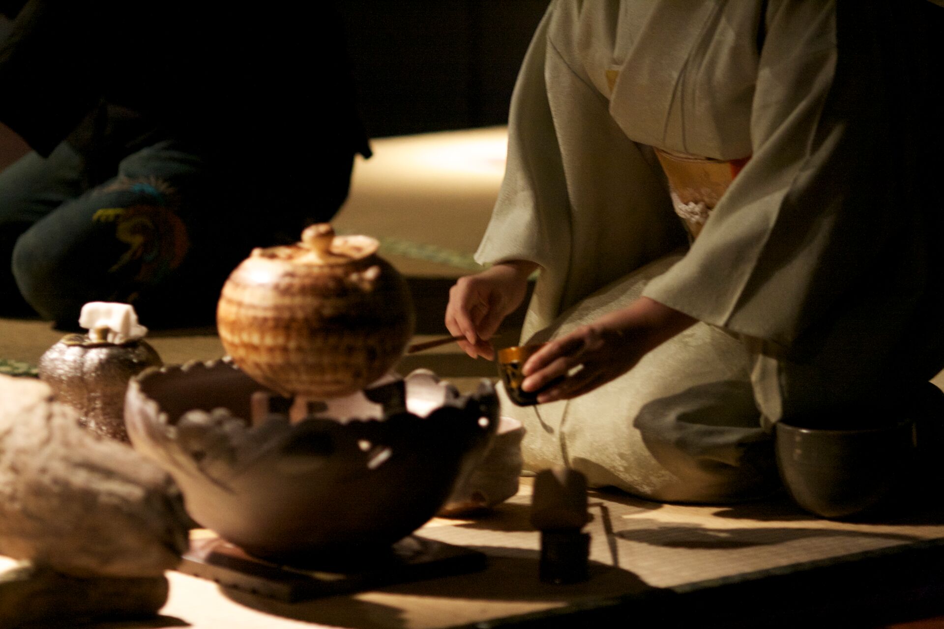 Woman in a traditional kimono performing a tea ceremony in Japan
