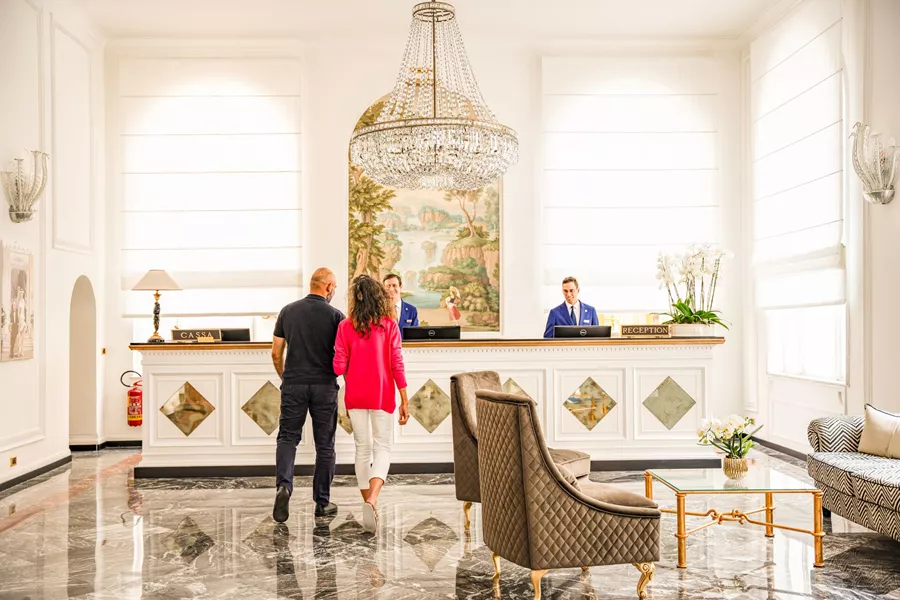 A couple entering rexeption at Grand Hotel Quisisana