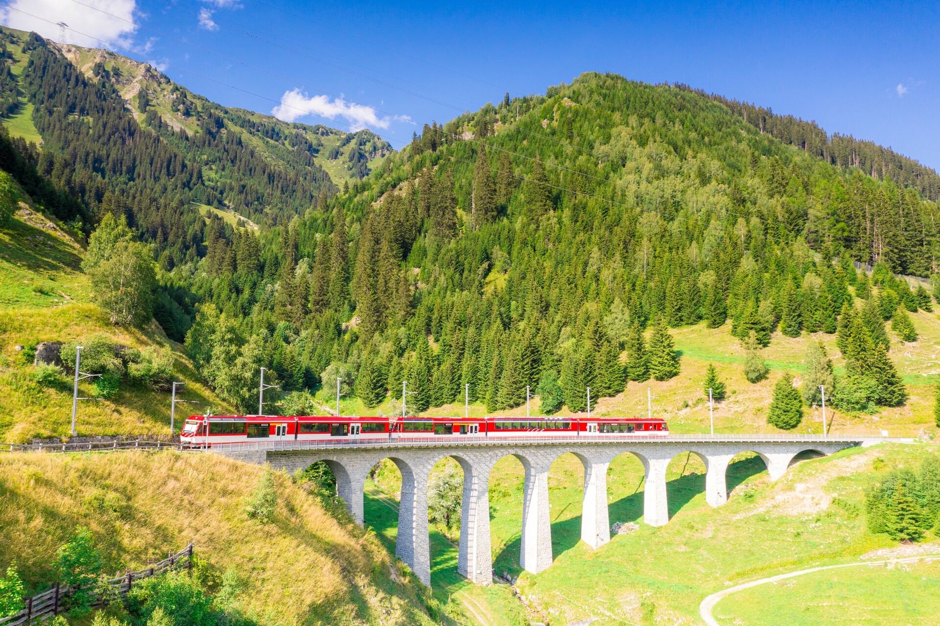 Glacier Express Train On Tujetsch Viaduct in a sunny day in Switzerland