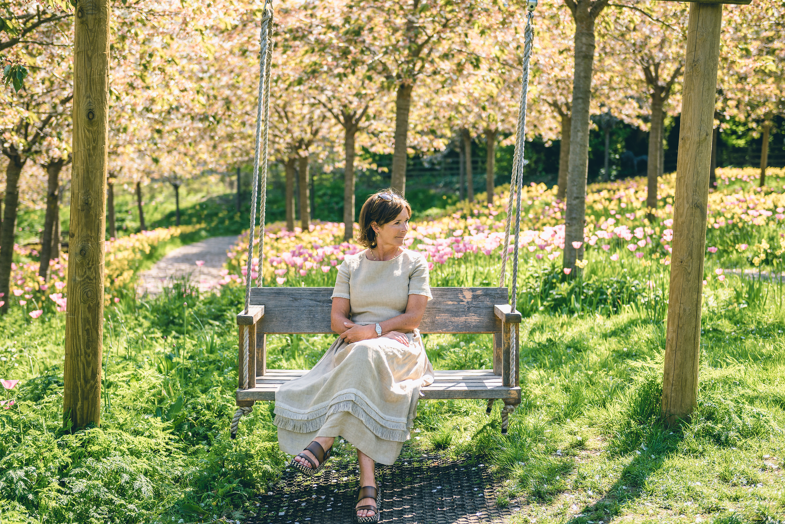 The Duchess of Northumberland sitting on a bench in a pretty garden in England