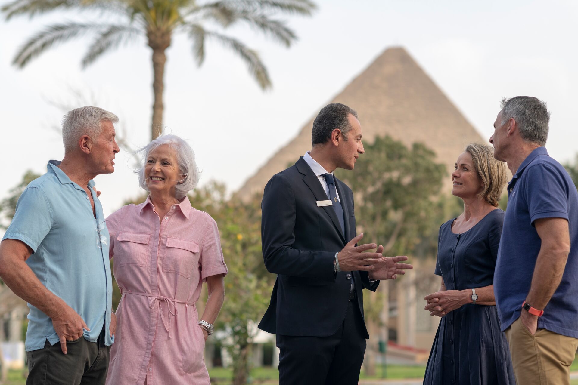 A group of people talking and marveling at pyramids in Egypt.