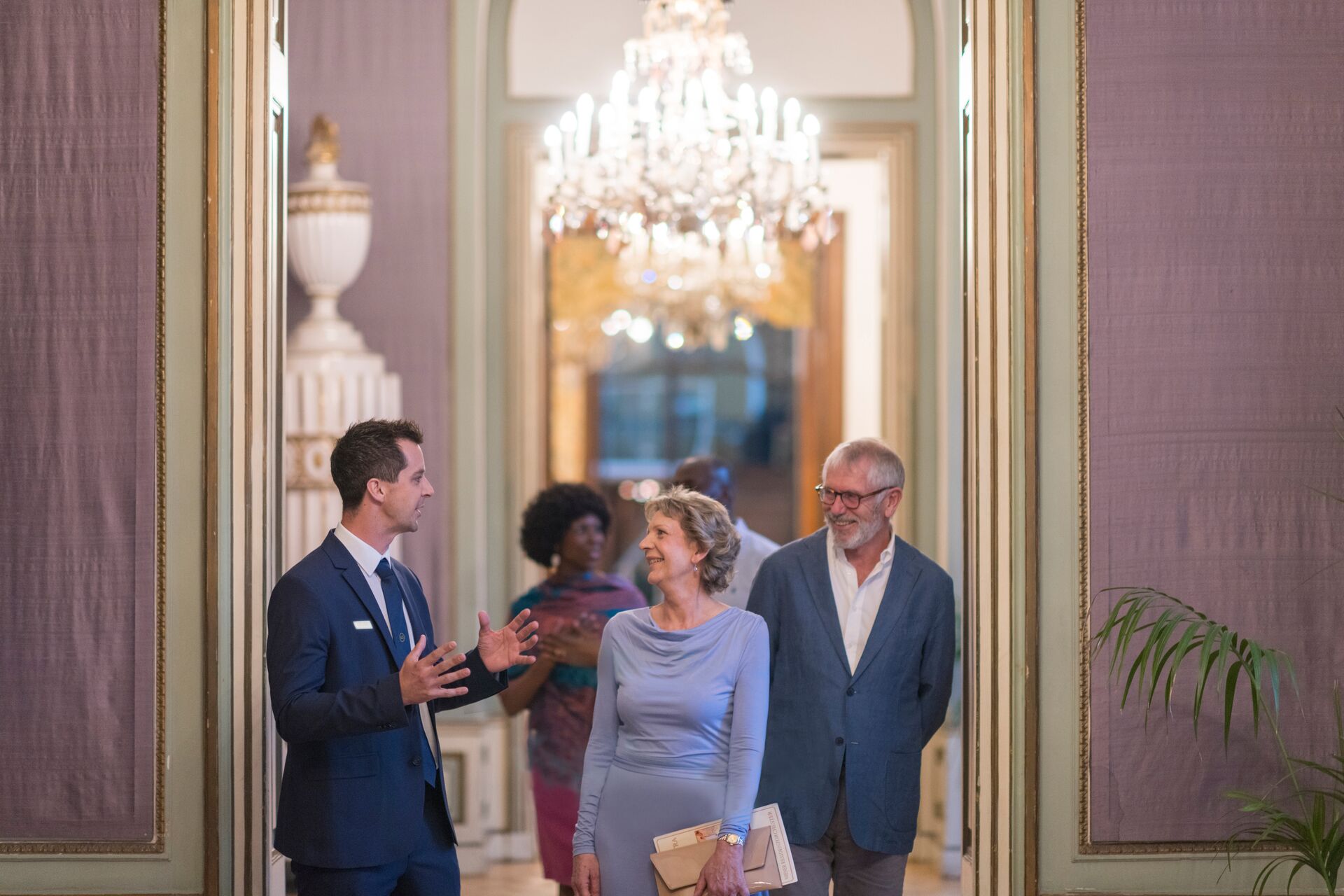 A Traveling Concierge engages two guests in conversation as they enter the Palais Auersperg in Vienna
