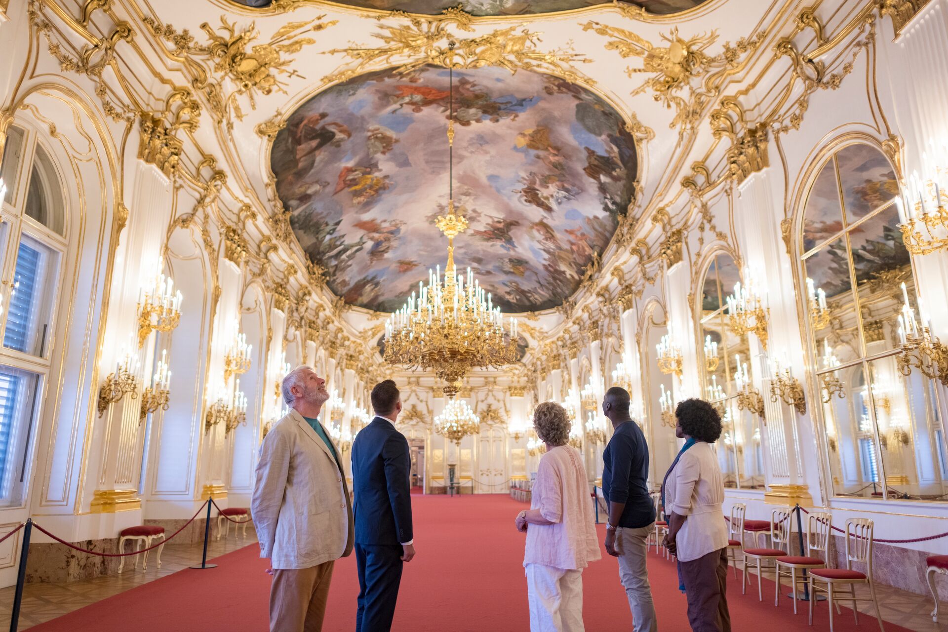A Luxury Gold small group tour admire a painted ceiling at the Schonbrunn Palace in Vienna