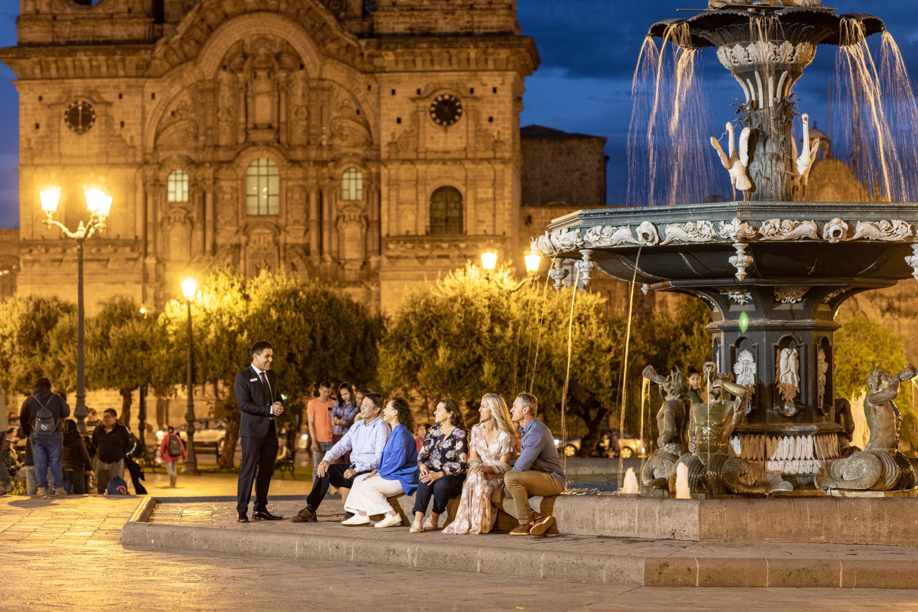 Group Of Tourist Sitting Next To Fountain