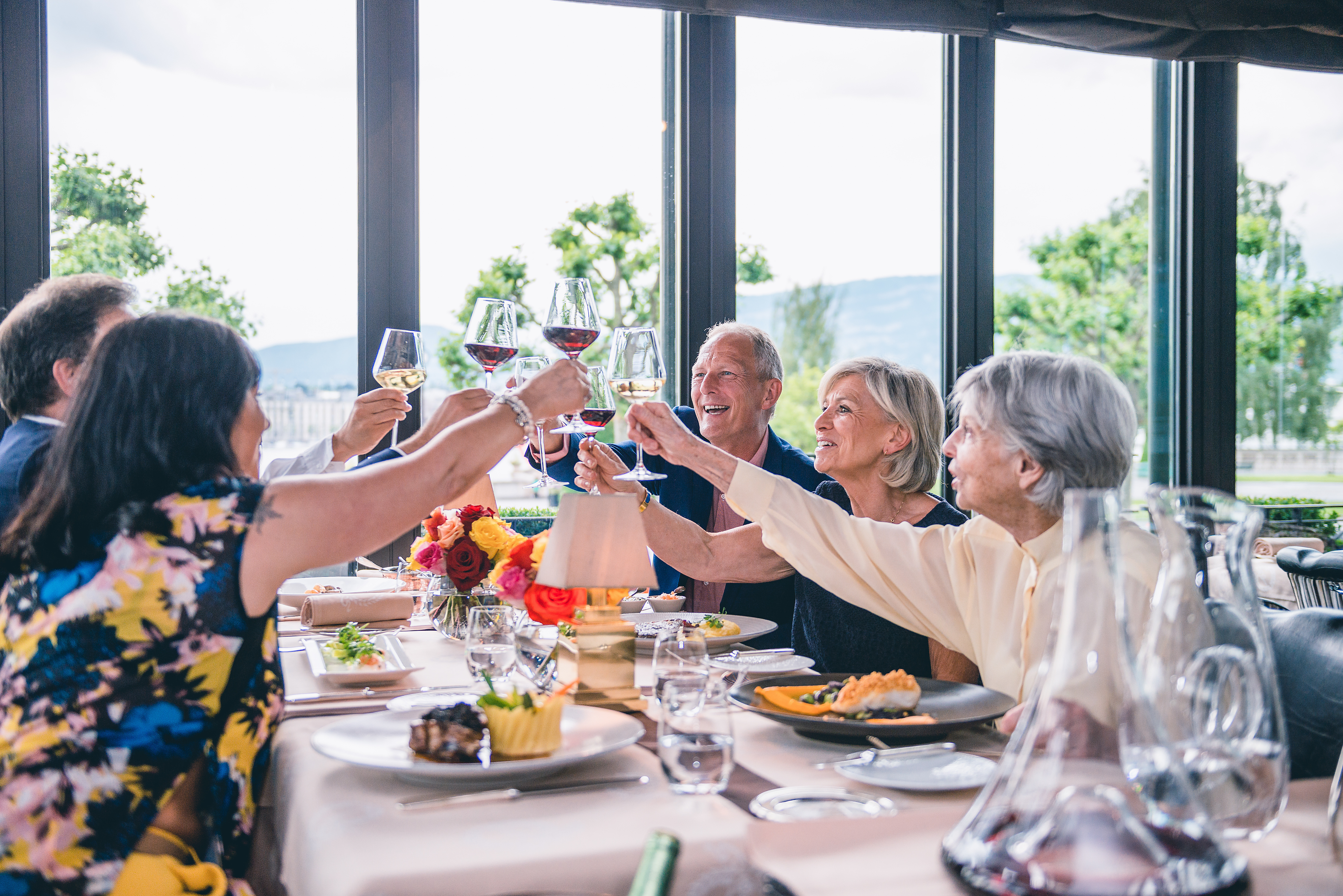 A group of people raising a toast while dining together