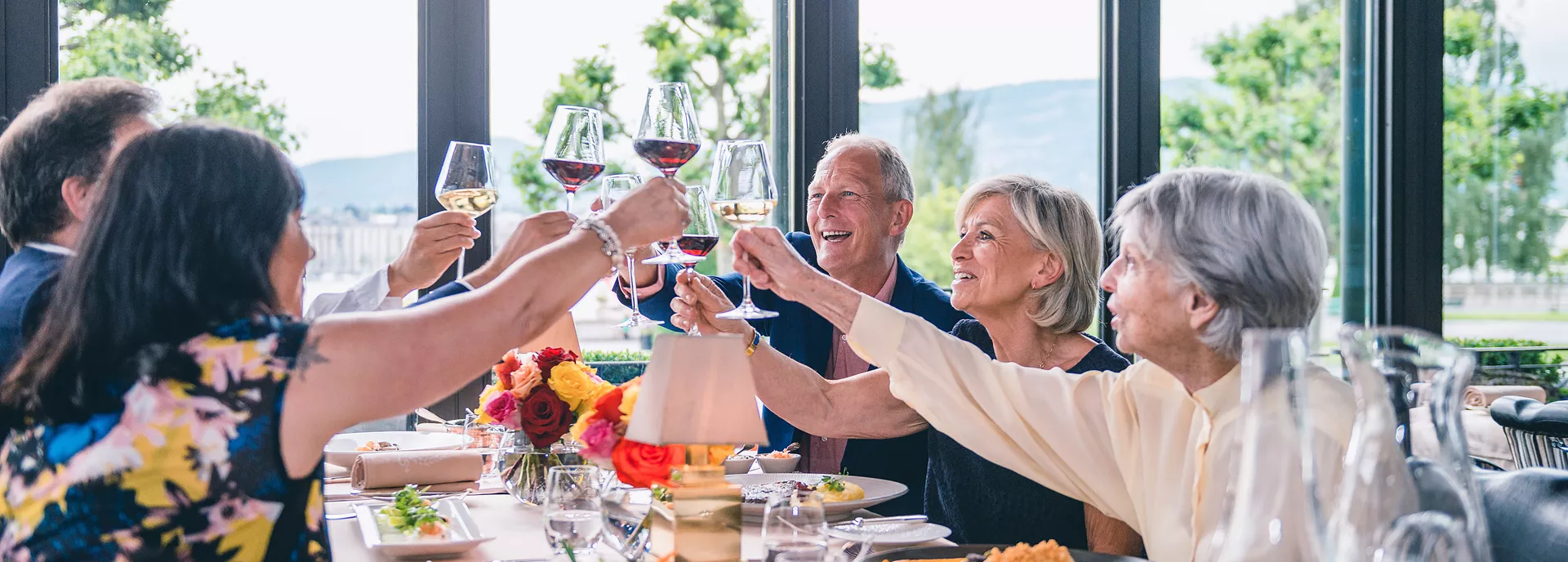 A group of people raising a toast while dining together