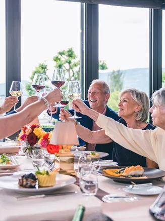 A group of people raising a toast while dining together