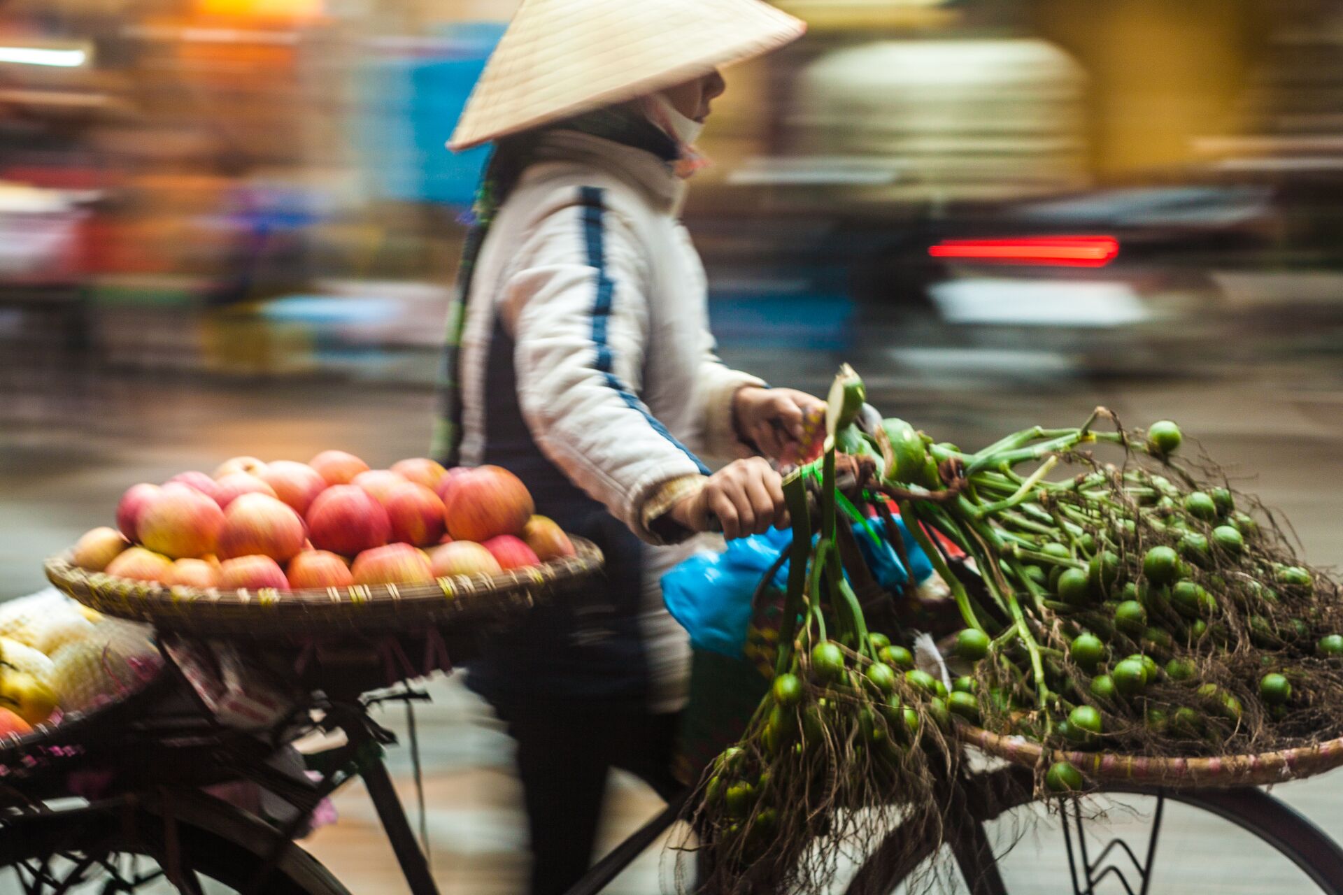 Blurred view of street vendor carrying fruits on a bicycle in Hoi An, Vietnam